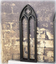 Dollhouse Gothic-style window frame against a textured stone wall