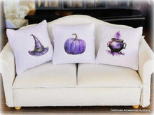 Dollhouse Three Halloween-themed pillows on a white couch purple witch theme