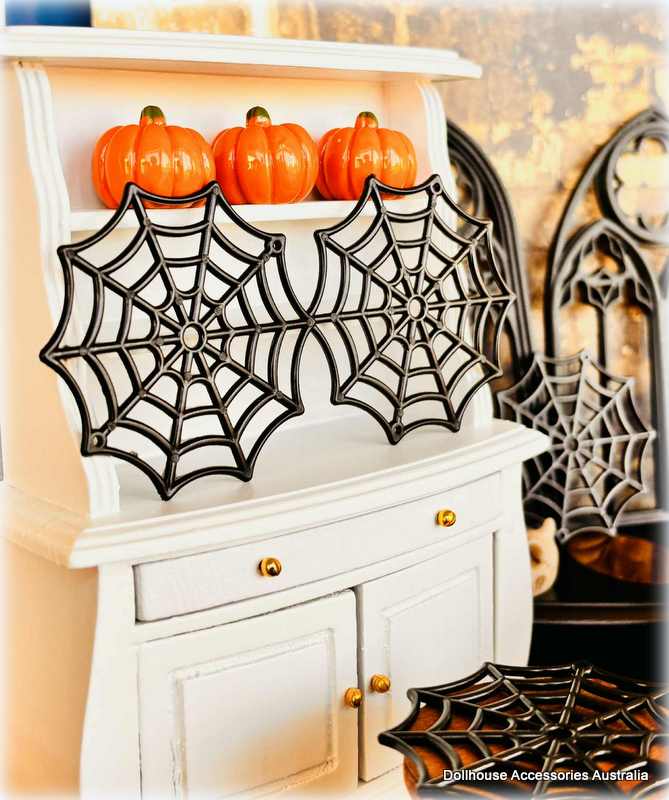 Dollhouse Miniature Halloween decorations spider webs and on a shelf.