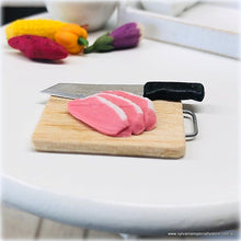 Dollhouse miniature uncooked meat knife on chopping board