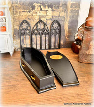 Black coffin with gold accents on a wooden surface, styled against a rustic background.