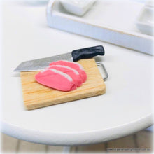 Dollhouse miniature uncooked meat knife on chopping board