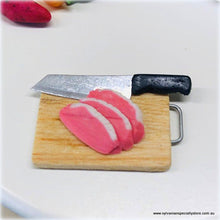 Dollhouse miniature uncooked meat knife on chopping board