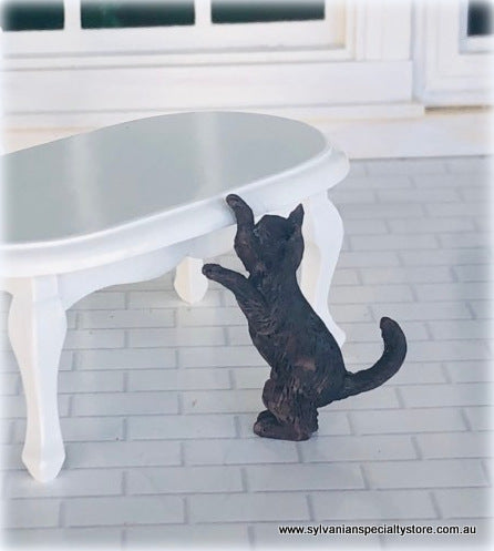 Dollhouse miniature black cat climbing